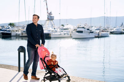 Father and daughter standing at harbor