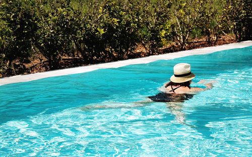 Woman in swimming pool against trees