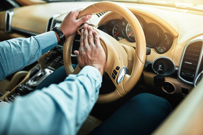 Midsection of man using mobile phone while sitting in car