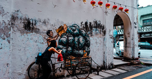 Woman standing by graffiti wall in city