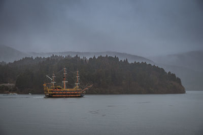 Ship sailing in sea against sky