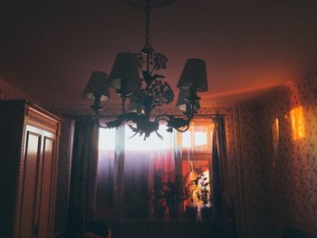 Illuminated chandelier hanging on ceiling at home