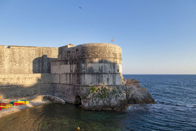 View of fort by sea against clear sky