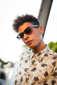 Portrait of young woman wearing sunglasses standing outdoors