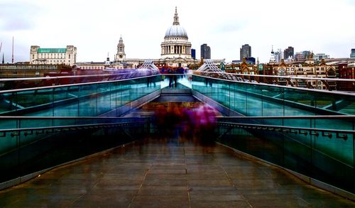 View of footbridge in city against sky