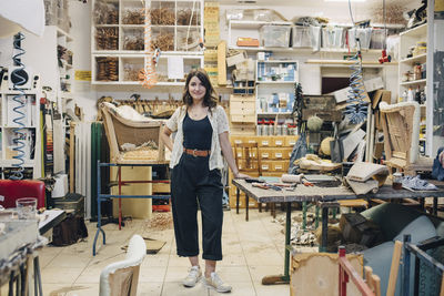 Portrait of confident female upholstery worker standing in workshop