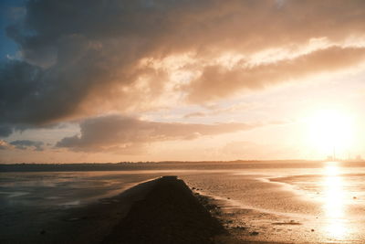 Scenic view of beach against sky during sunset