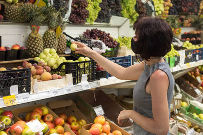 Young woman holding fruits at market stall