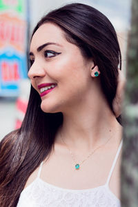 Close-up of young woman looking away while standing outdoors