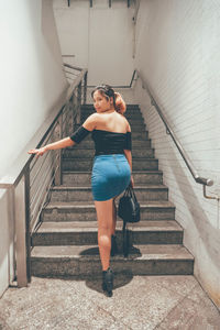 Full length of woman standing on staircase