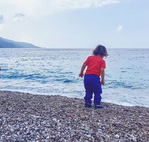 Rear view of boy standing on beach