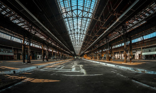 Empty road amidst buildings in city