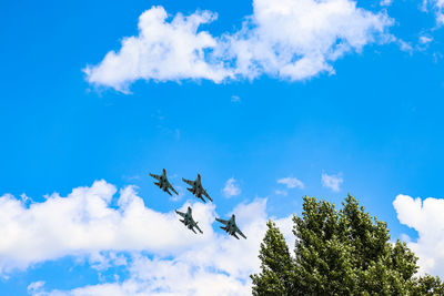 Low angle view of airplane flying against blue sky