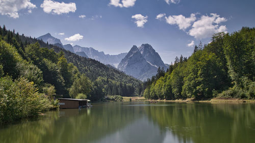 Scenic view of lake by trees against sky