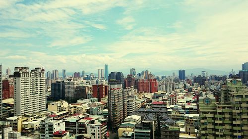 View of cityscape against cloudy sky