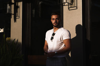 Young man standing against wall