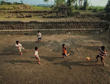 High angle view of boys playing soccer on land