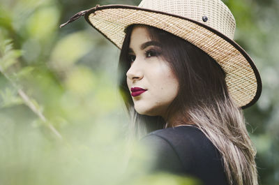 Close-up portrait of young woman wearing hat