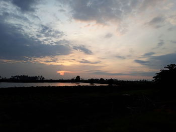 Scenic view of silhouette field against sky during sunset