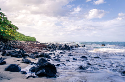 Rocks on beach against sky