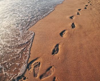 High angle view of footprints on sand at beach