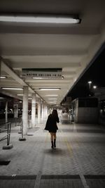 Full length rear view of woman walking in subway