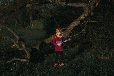 Full length of girl standing on tree