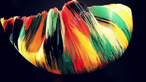 Close-up of colorful object over black background