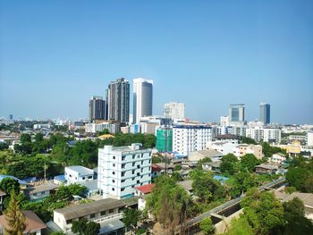 Buildings in city against clear blue sky