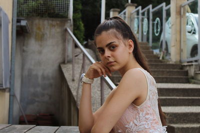 Portrait of young woman sitting outdoors