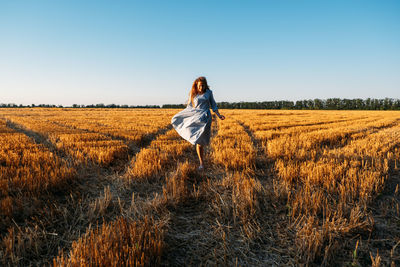 Woman in blue linen dress enjoying nature in sunset field. stress and psychological resilience