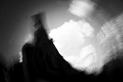 Low angle view of person on rock formation against sky