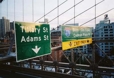 Information sign on road against buildings in city