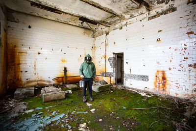 Rear view of woman standing in abandoned building