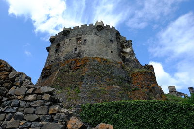 Low angle view of old building against cloudy sky