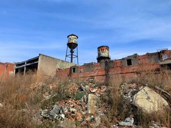 Low angle view of abandoned buildings against blue sky