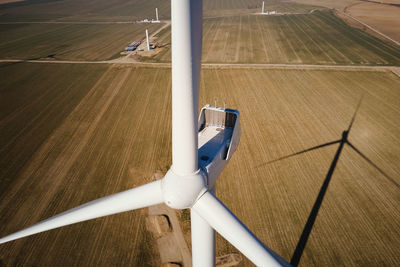 Aerial view of close up windmill turbine in countryside area, wind power and renewable energy