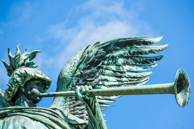 Low angle view of statue against blue sky