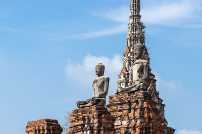 Low angle view of statue against building against sky