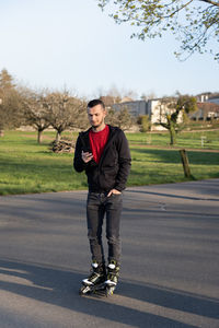 Young man on roller blade looking at his phone. technologie in nature.