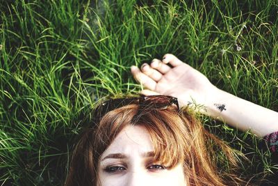 Portrait of woman lying down on field