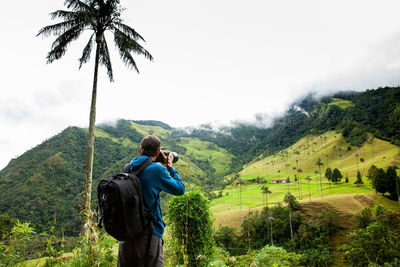 Tourist taking pictures at valle de cocora located in salento at the quindio region in colombia