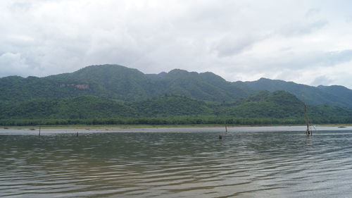 Scenic view of lake by mountains against sky