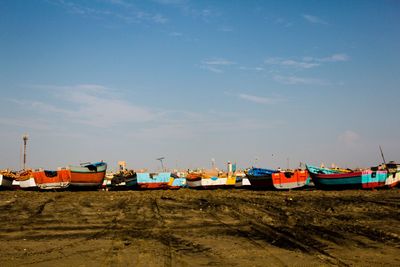 Boats moored on beach against sky