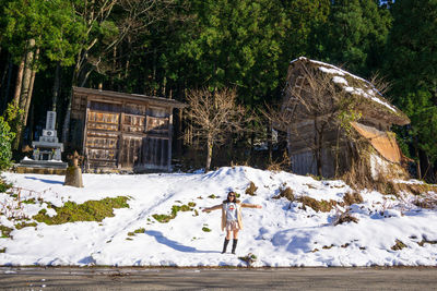 Rear view of woman standing on snow covered land