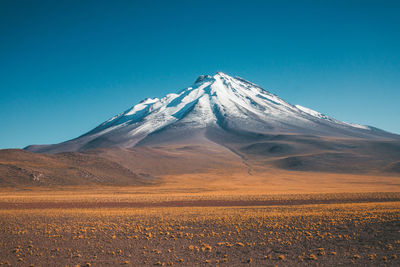 Scenic view of snowcapped mountains against clear blue sky