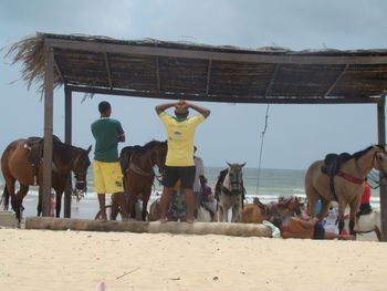 Panoramic view of people on sand against sky