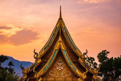 Low angle view of traditional building against sky during sunset