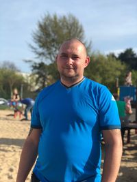 Portrait of man standing at beach against sky