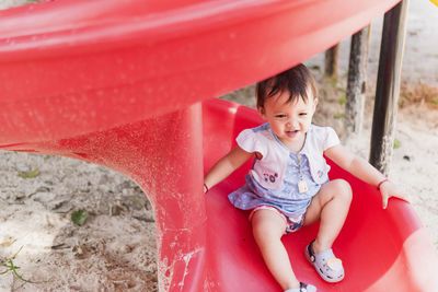 High angle view of baby girl playing with red ball